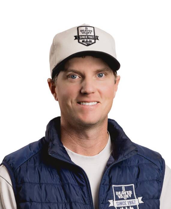 Smiling man wearing a beige cap with a Beaver Valley patch and a navy quilted vest over a light shirt.